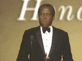 Celebrity gif. Sidney Pointer is accepting an award at the Oscars and he exhales heavily on stage while looking around. He puts a hand to his chest and he clutches himself, taking in the moment.