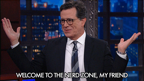 TV gif. Stephen Colbert throws up his hands and laughs as he says to left of frame: Text, "Welcome to the nerd zone, my friend."