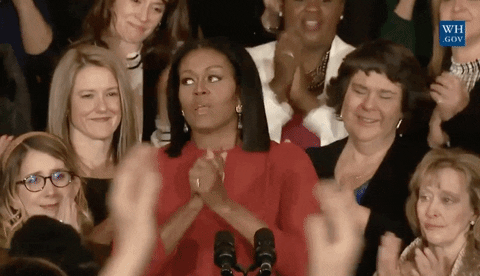 Michelle Obama exhales in relief and is hugged by surrounding women