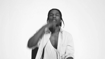 Celebrity gif. Black and white frame showing A$AP Rocky looks up, crossing his chest and then kissing his fingers and raising up heavenward.