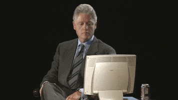 Celebrity gif. Bill Clinton looks down at an old computer screen. He nods his head and purses his lips as he gives a big thumbs up.