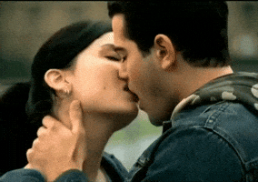 Music video gif. Brown-haired man and woman from video for 3 Doors Down "Let Me Go" kiss passionately outside.