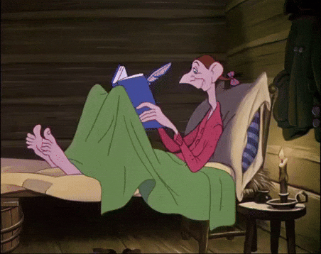 a cartoon character is laying on a bed reading a book .