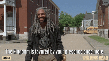 TV gif. Khary Payton as Ezekiel of The Walking Dead spreads his arms wide, holds up his gold cane, and says "The kingdom is favored by your presence once more!"