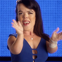 Reality TV gif. Briana Manson from Little Women LA has an impressed smile on her face as she claps at us proudly. Her navy blue dress corresponds well with the slightly brighter blue background.