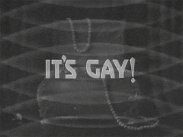 Text gif. Muted backdrop consists of overlapping, transparent gray ellipses that overlay an ajar jewelry box with pearl necklaces hanging off the edges. Increasing in size, opaque light gray text reads, "It's Gay!"