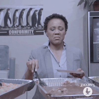Ad gif. Woman in office frowning, grossed out by the soupy food she's preparing to scoop onto her plate from a tinfoil dish.