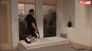 TV gif. Kevin James as Doug Hefferman on King of Queens falls on his knees onto a mattress on the floor. He leans forward slowly and flops down on his stomach onto the mattress.