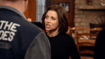TV gif. Julia Louis-Dreyfus, as Selina in Veep, gives several people a high five and yells, “Good job!”