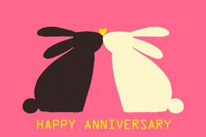 Digital art gif. Two bunnies kiss as a heart floats up between them. Text, “Happy Anniversary.”