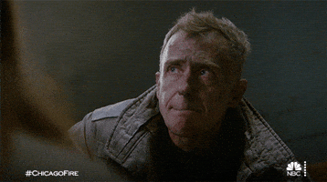 TV gif. David Eigenberg as Christopher in Chicago Fire bites his lip and nods his head in agreement as he holds back tears. 