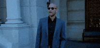 TV gif. Keegan-Michael Key, dressed in a suit outside a marble building, takes off his sunglasses and looks out in amazement while mouthing, "Holy shit," which appears as text.