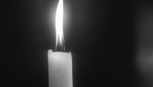 Černobílý gif na dušičky se zhasínající svíčkou.