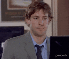 The Office gif. John Krasinski as Jim sits at his computer, briefly glancing at us as he mutters to himself. Text, "...Psychopath."