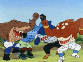 Cartoon gif. Group of four muscular sharks that walk on two legs from TV show Street Sharks pump their fists in the air while grinning and dancing in celebration, showing off their pointy chompers.
