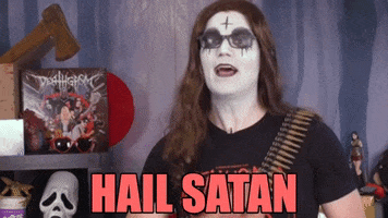 Video gif. Zoran Gvojic from The Kill Count on YouTube has his face painted black and white with a cross in the middle of his forehead. He gives us a broad smile and a big wave while he says, "Hail Satan!"