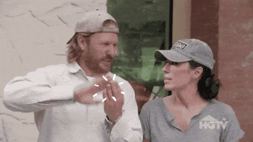 Text gif. Chip and Joanna Gaines, Chip sliding hand over hand in a make it rain gesture, green bubble letters flying from his palms assembling into the message "Home renovation rebates."