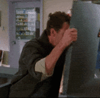 Video gif. A man slams a hinged counter back and forth as he appears to hit his head against it.