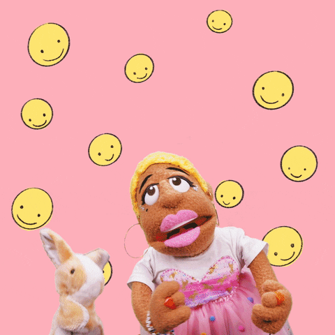 Video gif. A girl puppet and a bunny puppet dance together while smiley faces rotate in the background. Text, "Friyay."