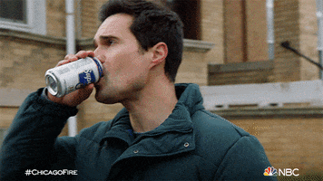 TV gif. In a scene from Chicago Fire, a man takes a casual sip from a can of beer, then spins around and throws it at a building.
