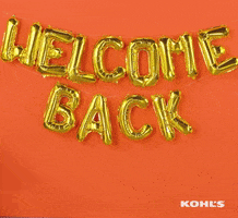 Ad gif. A sign made out of foil balloons hangs on the wall and a woman on a desk chair rolls into frame, smiling and giving a thumbs up before rolling off screen. Text, "Welcome Back"