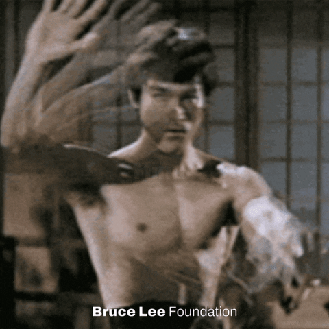 Bruce Lee gif. Bruce Lee, shortless and in a martial arts dojo, slowly moves his outstretched arms up and down in front of himself, undulating his hands as he stares into our souls. White text that appears to move between his hands reads, "Mind, body, spirit." Text at the bottom of the screen reads, "Bruce Lee Foundation."