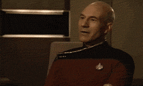 TV gif. Patrick Stewart as Captain Jean-Luc on Star Trek: The Next Generation, Shakes his head and smiles proudly at someone off screen, clapping as he says, "Well done."