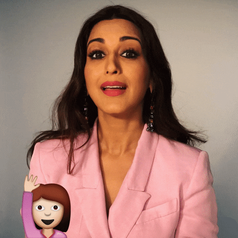 Celebrity gif. Sonali Bendre raises a hand and gives us a quick wave with a warm smile. The waving hi woman emoji is on the bottom with the text, "Hello!"