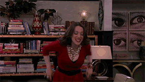TV gif. Kat Dennings as Max Black from 2 Broke Girls wears a festive red dress, which doesn't hide her armpit stains very well. She raises her arms in celebration but quickly notices her sweaty armpits and sets them down.