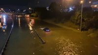 Vehicles Drive Through Flooded Highway in Lansing