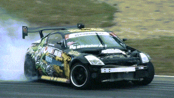 Sports gif. A professional Nissan 350z Tokyo drifts, wheels smoking, and recovers.