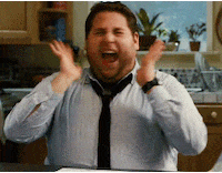 Movie gif. Jonah Hill as Aaron in Get Him to the Greek sits in a kitchen and squeals, turning left and right and fanning the sides of his face.