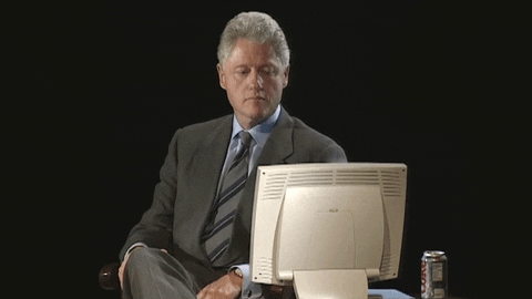 Celebrity gif. Bill Clinton looks down at an old computer screen. He nods his head and purses his lips as he gives a big thumbs up.
