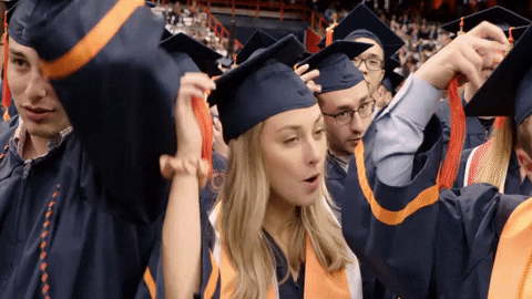A group of people is adjusting their graduation hats.