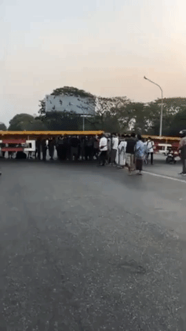 Crowd Push Apart Truck Trailers Blocking Bridge in Yangon