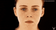 Video game gif. Closeup of just Sophia Lillis" face and neck, eyes lowered and welling up with tears. All of a sudden, she shakes with intensity and screams, looking at us with a terrified expression. 