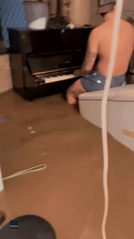Man Plays Piano in Flooded Garage