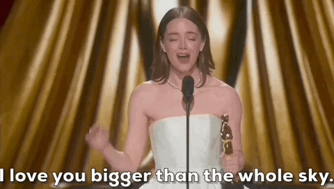 Oscars 2024 GIF. Emma Stone gestures widely with her arms while she tearfully says, "I love you bigger than the whole sky."