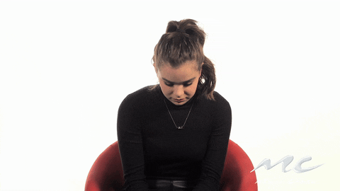 Celebrity gif. Hailee Steinfeld sharply looks up from her seat and glances around and behind her before pointing at herself and saying, "Me?"