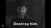SNL gif. Parody of a period drama TV show. A man in a Victorian-era outfit, including a top hat and a dark coat displays a serious expression and intense gaze. The caption, "Destroy him." is shown at the bottom of the scene.