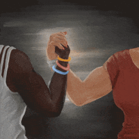 Digital art gif. Two people flex their biceps as they clasp hands in front of a gray painted background. Text, “Reproductive rights and LGBTQ+ equals fight for bodily autonomy.”