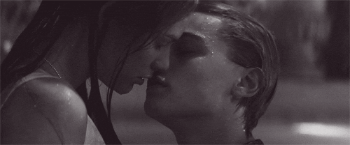 Movie gif. Leonardo DiCaprio as Romeo and Claire Danes as Juliet in Romeo and Juliet are in a pool. Romeo reaches up to kiss Juliet.