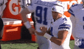 Sports gif. On the sidelines, Dallas Cowboys player Dak Prescott claps his hands together in encouragement.