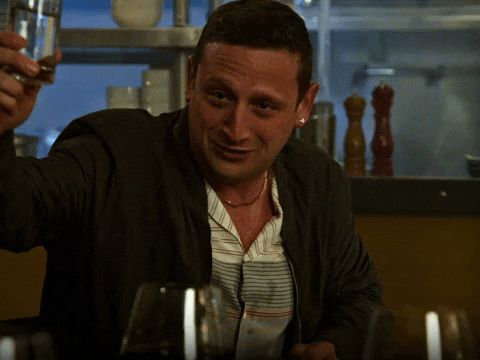 TV gif. Tim Robinson from I Think You Should Leave with Tim Robinson. He's drunk and has his glass in the air, raising a toast while wetly saying, "To friends!"