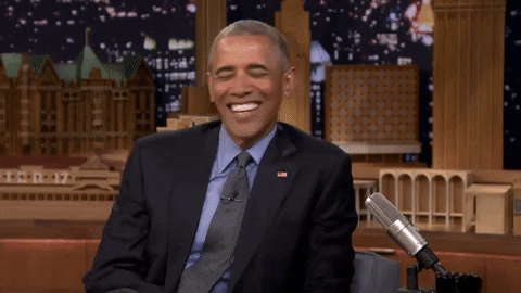 Political gif. On the Jimmy Fallon Show, Barack Obama reacts to something funny, hunching over and laughing.