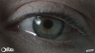 TV gif. A scene from the Outcast. A close up of a blue eye that blinks and tears leak out. 