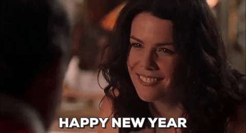 Movie gif. Lauren Graham as Sue in Bad Santa smiles and says, "Happy New Year," which appears as text, and then she downs a shot.