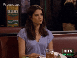 Sponsored GIF. Cobie Smulders sits in a restaurant booth in a conversation of negotian. She takes a quick pause, cants her head to the side and defiantly offers “The best I can give you is a fake smile and dead eyes.”Spons