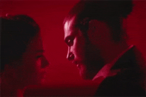 TV gif. A red-toned closeup of the central characters from Daydreamer closing in for a kiss.