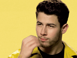 Celebrity gif. Nick Jonas looks at us and brings his hand up to his lips, making a chef's kiss gesture with his hand and lips.